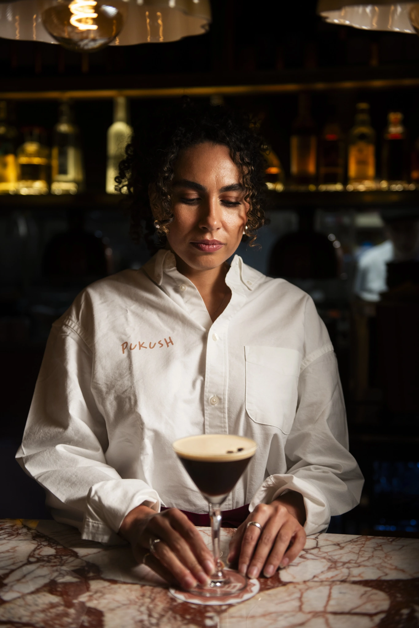 Pukush team member serving an espresso martini at the bar